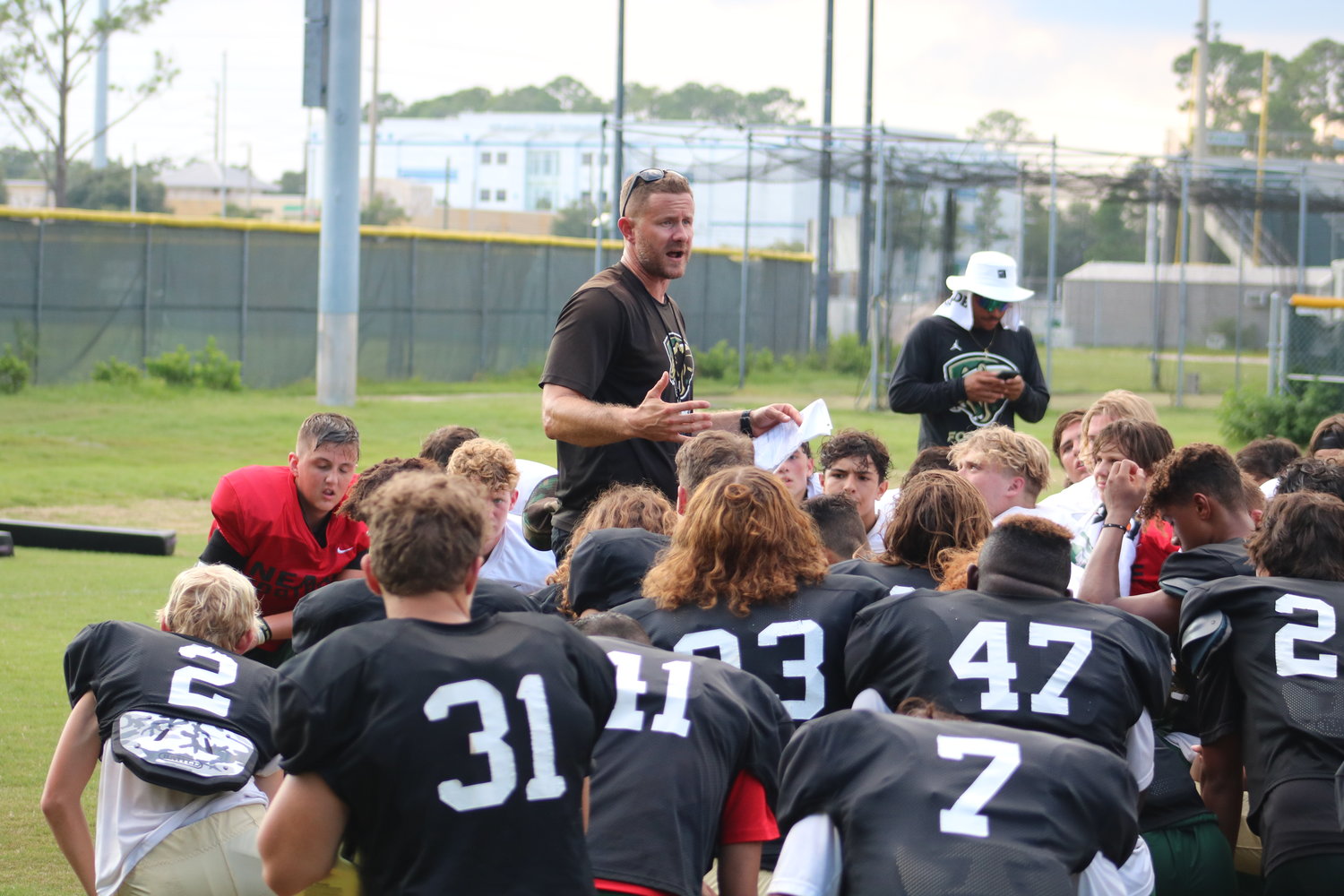 Nease head coach Collin Drafts speaks to the team following practice.